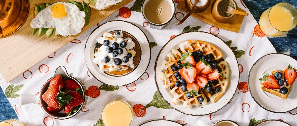 Mesa de café da manhã com waffles e frutas